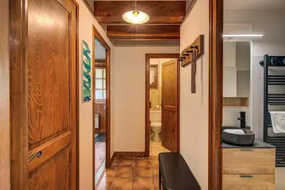 a bathroom with a toilet and a wooden door at Apartment Grand Payot, Alpes Travel, Sleeps 2 to 4 in Chamonix-Mont-Blanc