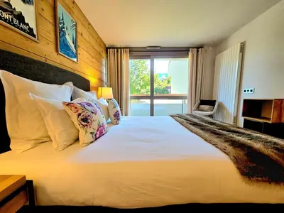 a bedroom with a large white bed with a window at Modern apartment Rochebrune ski in ski out in Megève