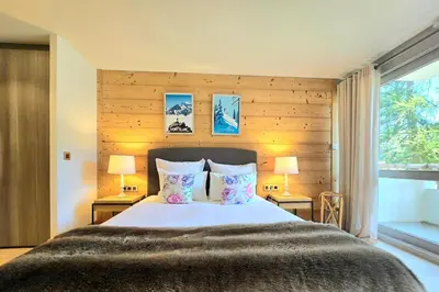 a bedroom with a bed with two lamps and a window at Modern apartment Rochebrune ski in ski out in Megève