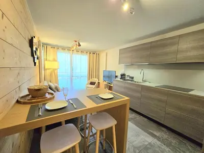 a kitchen with a table and some chairs and a counter at Modern apartment Rochebrune ski in ski out in Megève