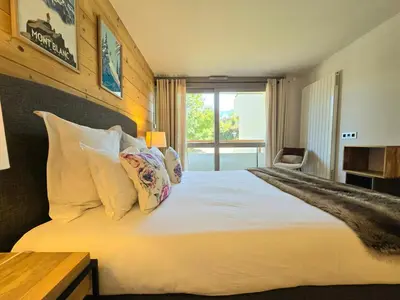 a bedroom with a large bed with white sheets and pillows at Modern apartment Rochebrune ski in ski out in Megève