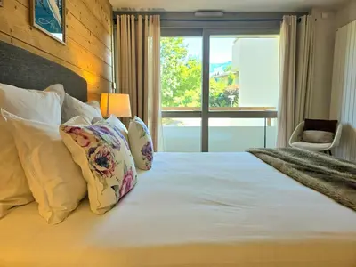 a bedroom with a bed with pillows and a window at Modern apartment Rochebrune ski in ski out in Megève