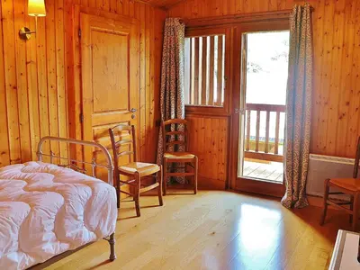 a bedroom with a bed and two chairs and a window at Chalet spacieux à Samoëns, proche village, jusqu'à 11 personnes, WiFi, parking - FR-1-815-3 in Samoëns