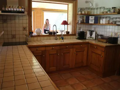 a woman sitting in the window of a kitchen at Chalet spacieux à Samoëns, proche village, jusqu'à 11 personnes, WiFi, parking - FR-1-815-3 in Samoëns