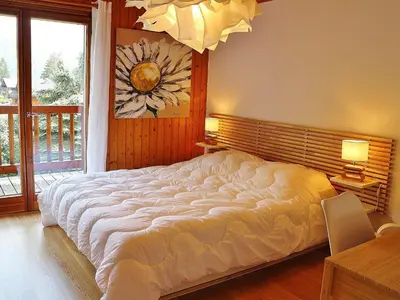 a large white bed in a bedroom with a window at Chalet spacieux à Samoëns, proche village, jusqu'à 11 personnes, WiFi, parking - FR-1-815-3 in Samoëns