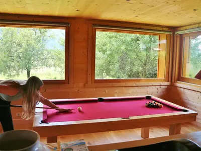 a girl playing pool in a billiard room at Chalet spacieux à Samoëns, proche village, jusqu'à 11 personnes, WiFi, parking - FR-1-815-3 in Samoëns