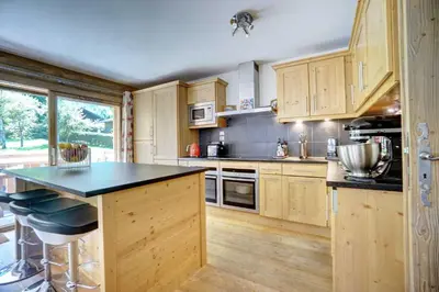 a kitchen with wooden cabinets and a black counter top at Hameaux du glaciers in Les Houches