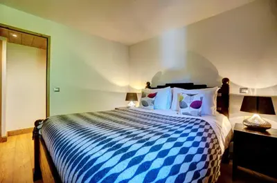 a bedroom with a blue and white bed with two lamps at Hameaux du glaciers in Les Houches