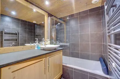a bathroom with a tub and a sink and a bath tub at Hameaux du glaciers in Les Houches