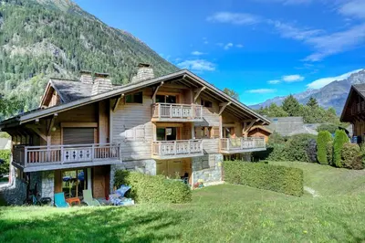 a large wooden house with a balcony on a mountain at Hameaux du glaciers in Les Houches