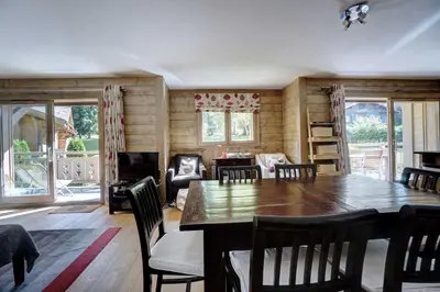 a dining room with a wooden table and chairs at Hameaux du glaciers in Les Houches