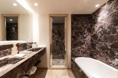 a bathroom with a bath tub and a sink at Le Refuge Chez La Tante - Mont d'Arbois, ski in - ski out in Saint-Gervais-les-Bains