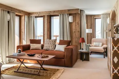 a living room with a brown couch and a table at Le Refuge Chez La Tante - Mont d'Arbois, ski in - ski out in Saint-Gervais-les-Bains