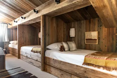 two beds in a room with wooden walls at Le Refuge Chez La Tante - Mont d'Arbois, ski in - ski out in Saint-Gervais-les-Bains