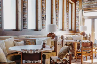 a dining room with tables and chairs and windows at Le Refuge Chez La Tante - Mont d'Arbois, ski in - ski out in Saint-Gervais-les-Bains
