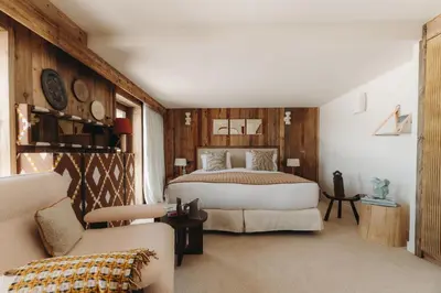 a bedroom with a bed and a chair and a couch at Le Refuge Chez La Tante - Mont d'Arbois, ski in - ski out in Saint-Gervais-les-Bains