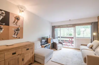 a living room with a couch and a tv at Studio Capucines - Welkeys in Megève