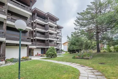 an apartment building with a walkway in a park at Studio Capucines - Welkeys in Megève