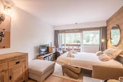 a bedroom with a large bed and a television at Studio Capucines - Welkeys in Megève