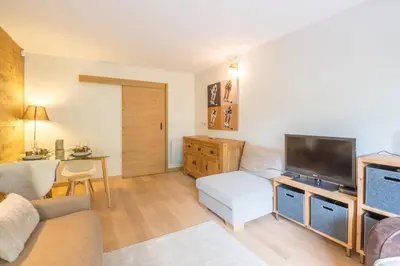 a living room with a couch and a flat screen tv at Studio Capucines - Welkeys in Megève