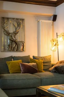 a living room with a couch and a picture of a deer at Pothecary apartment -Chamonix All Year in Chamonix-Mont-Blanc
