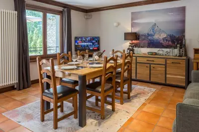 a dining room with a wooden table and chairs at Pothecary apartment -Chamonix All Year in Chamonix-Mont-Blanc