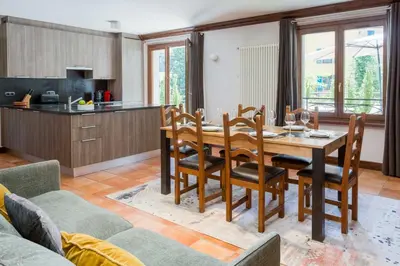 a kitchen and dining room with a wooden table and chairs at Pothecary apartment -Chamonix All Year in Chamonix-Mont-Blanc