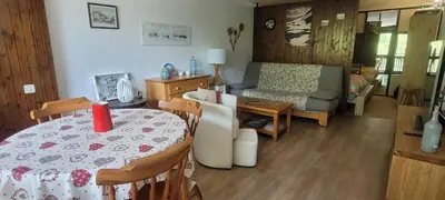a living room with a table and a couch at Grand studio près Lac Gaillands in Chamonix-Mont-Blanc