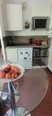 a kitchen with a glass table with a plate of fruit at Grand studio près Lac Gaillands in Chamonix-Mont-Blanc
