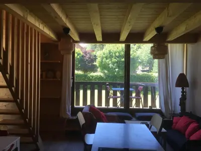 a living room with a table and a large window at Appartement exceptionnel au Lavancher à chamonix in Chamonix-Mont-Blanc