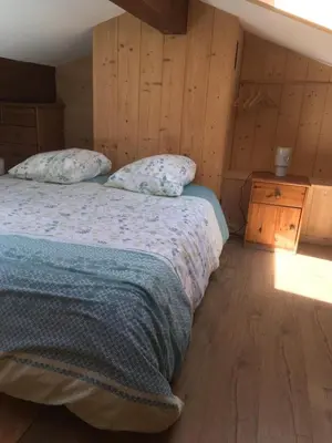 a bedroom with a bed and a wooden floor at Appartement exceptionnel au Lavancher à chamonix in Chamonix-Mont-Blanc