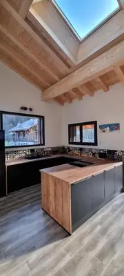 a kitchen with a large island in a room with wooden ceilings at Appart 3 pièces Cosy - idéal famille & sports Le Cairn De Samoëns in Samoëns