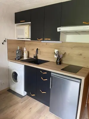 a kitchen with a sink and a washing machine at L'aiguille in Saint-Gervais-les-Bains