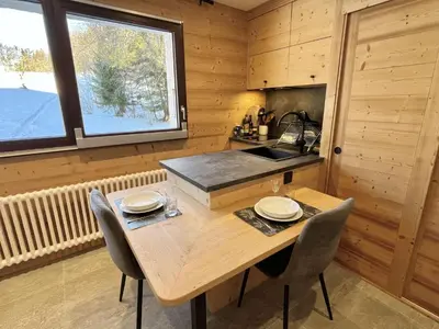 a wooden kitchen with a wooden table and chairs at Appartement Studio, 2 couchages, MEGEVE MEG400-T122 in Megève