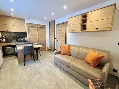 a living room with a couch and a kitchen at Appartement Studio, 2 couchages, MEGEVE MEG400-T122 in Megève