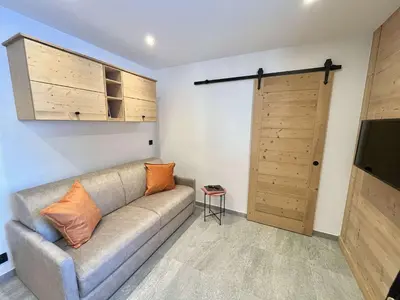 a living room with a couch and a sliding door at Appartement Studio, 2 couchages, MEGEVE MEG400-T122 in Megève