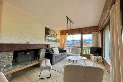 a living room with a couch and a fireplace at Balcon des cimes - 80 m in Combloux