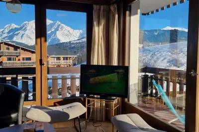 a bedroom with a white bed with a window at Balcon des cimes - 80 m in Combloux