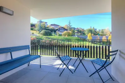 a balcony with a table and chairs and a fence at Open the door and Hike, Ski or Bike 3 Br Apartment Saint Gervais in Saint-Gervais-les-Bains