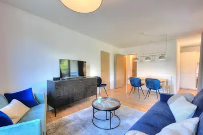 a living room with a blue couch and a table at Open the door and Hike, Ski or Bike 3 Br Apartment Saint Gervais in Saint-Gervais-les-Bains