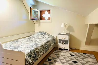 a small bedroom with a bed and a night stand at Spacious chalet in Chamonix with Mont Blanc view in Chamonix-Mont-Blanc