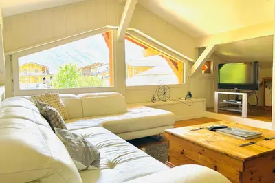 a living room with a white couch and a tv at Spacious chalet in Chamonix with Mont Blanc view in Chamonix-Mont-Blanc