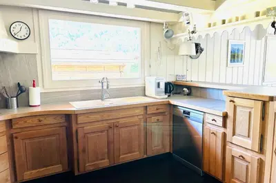 a kitchen with wooden cabinets and a window and a sink at Spacious chalet in Chamonix with Mont Blanc view in Chamonix-Mont-Blanc