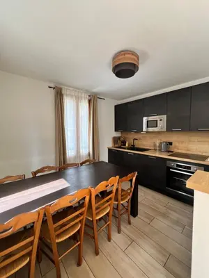 a kitchen with a dining room table and chairs at Duplex MontBlanc - Suite, Centre & Parking by AlpenlySallanches in Sallanches