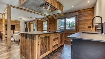 an open kitchen with a large island with bar stools at Chalet Follette in Chamonix-Mont-Blanc