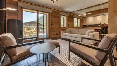 a room with wooden walls and two chairs and stairs at Chalet Follette in Chamonix-Mont-Blanc