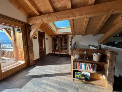 a living room with a vaulted ceiling and a book shelf at Beautiful chalet with panoramic views in Samoens walking distance to the village in Samoëns
