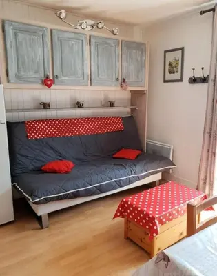a bed in a room with a red and white mattress at Au pied des pistes Studio 4 personnes in Morillon