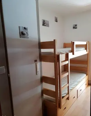 a room with two bunk beds and a refrigerator at Au pied des pistes Studio 4 personnes in Morillon