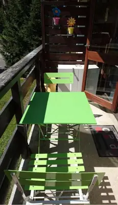 a green table sitting on top of a patio at Au pied des pistes Studio 4 personnes in Morillon